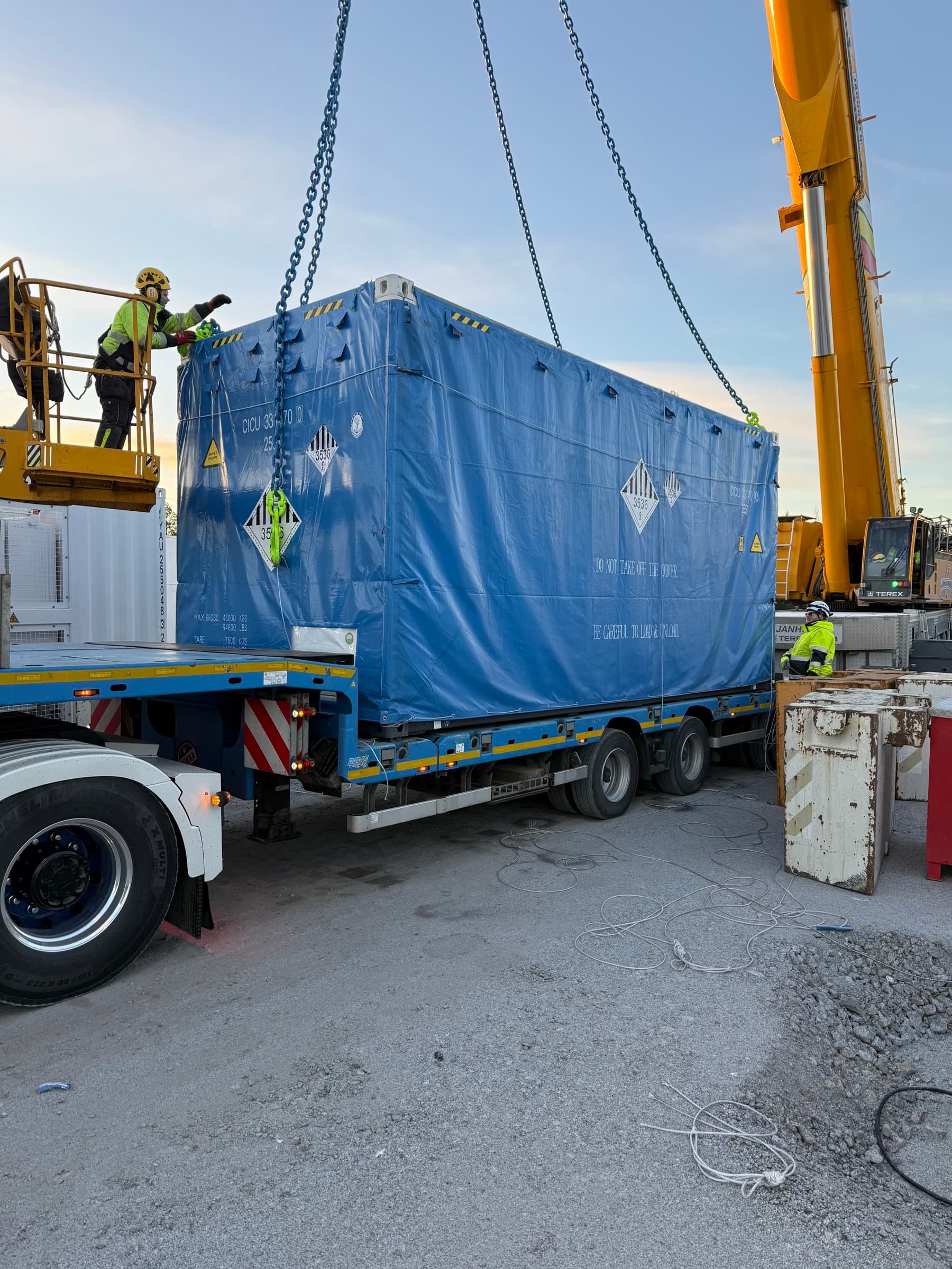 Contenedor de batería descargado de un camión con grúa