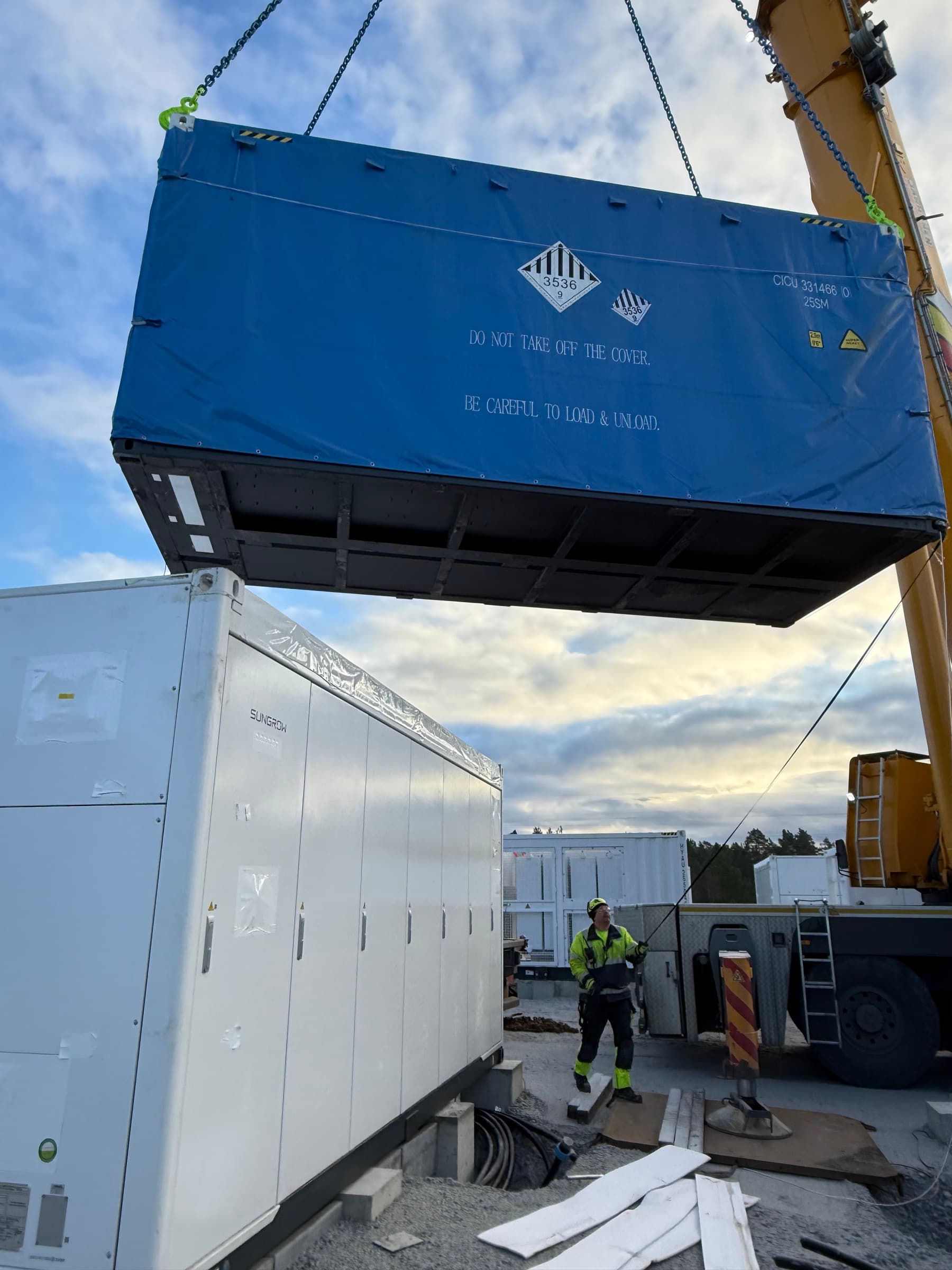 Contenedor de batería colocado sobre cimientos con grúa